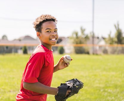 A,Portrait,Of,Child,With,Glove,And,Looking,At,Camera